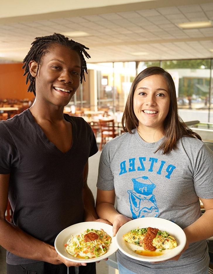 two students display their full plates of food in McConnell Dining Hall