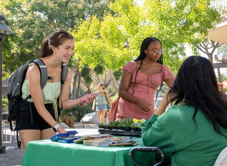 Two students sign up for a program at a Strive 2 Thrive table